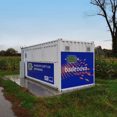 Seecontainer mit Aufschrift badenova vor einem Maisfeld